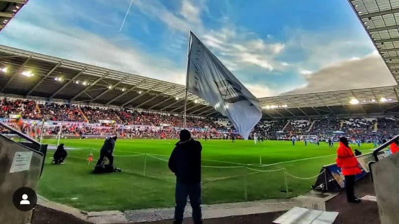 A flag flying pitchside at a Swansea City home game
